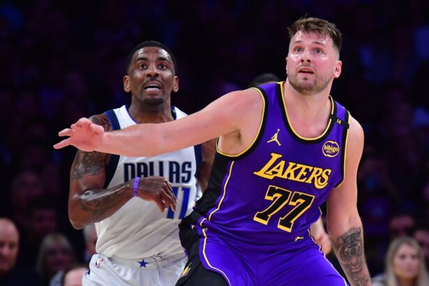 Feb 25, 2025; Los Angeles, California, USA; Los Angeles Lakers guard Luka Doncic (77) and Dallas Mavericks guard Kyrie Irving (11) attempt to gain control during the first quarter at Crypto.com Arena. Mandatory Credit: Gary A. Vasquez-Imagn Images