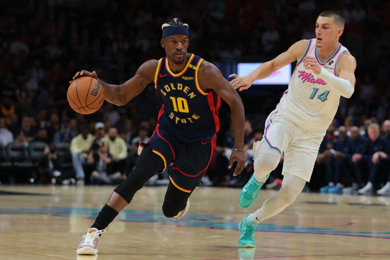 Mar 25, 2025; Miami, Florida, USA; Golden State Warriors forward Jimmy Butler III (10) drives to the basket past Miami Heat guard Tyler Herro (14) during the first quarter at Kaseya Center. Mandatory Credit: Sam Navarro-Imagn Images