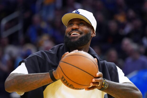 Oct 5, 2025; San Francisco, California, USA; Los Angeles Lakers forward LeBron James (23), wearing a Los Angeles Dodgers hat, watches from the sideline during a break against the Golden State Warriors in the third quarter at Chase Center. Mandatory Credit: David Gonzales-Imagn Images