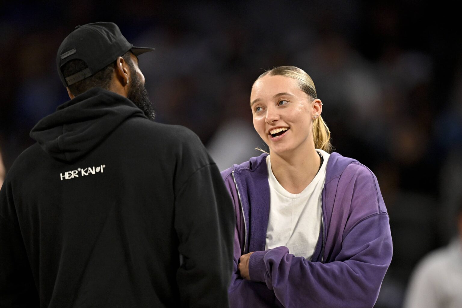 Oct 6, 2025; Fort Worth, Texas, USA; Dallas Mavericks guard Kyrie Irving (left) talks with Dallas Wings guard Paige Bueckers (right) during the second half of the game between the Mavericks and the Oklahoma City Thunder at Dickie's Arena. Mandatory Credit: Jerome Miron-Imagn Images