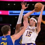 Oct 12, 2025; Los Angeles, California, USA; Los Angeles Lakers guard Austin Reaves (15) is defended by Golden State Warriors center Quinten Post (21) in the first half at Crypto.com Arena. Mandatory Credit: Jayne Kamin-Oncea-Imagn Images