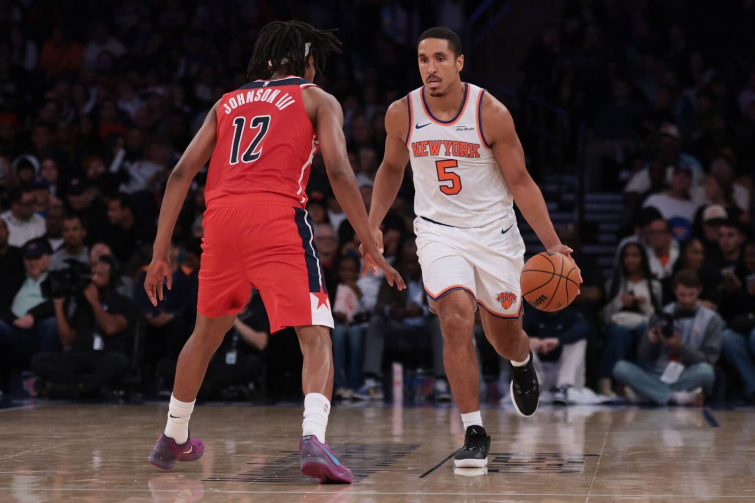 Oct 13, 2025; New York, New York, USA; New York Knicks guard Malcolm Brogdon (5) dribbles against Washington Wizards guard Tre Johnson (12)during the first half at Madison Square Garden. Mandatory Credit: Vincent Carchietta-Imagn Images