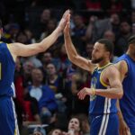 Oct 14, 2025; Portland, Oregon, USA; Golden State Warriors guard Stephen Curry (30) high fives center Quinten Post (21) during the second half against th Portland Trail Blazers at Moda Center. Mandatory Credit: Troy Wayrynen-Imagn Images