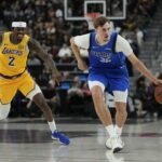 Oct 15, 2025; Las Vegas, Nevada, USA; Dallas Mavericks forward Cooper Flagg (32) dribbles the ball past Los Angeles Lakers forward Jarred Vanderbilt (2) during the first half at T-Mobile Arena. Mandatory Credit: Lucas Peltier-Imagn Images