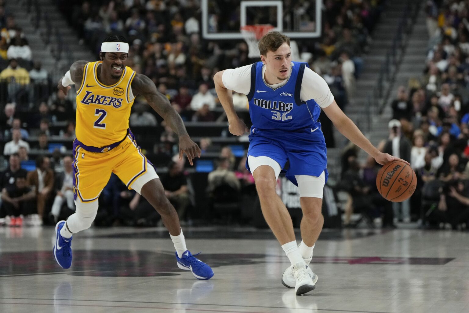 Oct 15, 2025; Las Vegas, Nevada, USA; Dallas Mavericks forward Cooper Flagg (32) dribbles the ball past Los Angeles Lakers forward Jarred Vanderbilt (2) during the first half at T-Mobile Arena. Mandatory Credit: Lucas Peltier-Imagn Images
