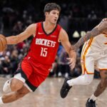 Oct 16, 2025; Atlanta, Georgia, USA; Houston Rockets guard Reed Sheppard (15) dribbles past Atlanta Hawks guard Nickeil Alexander-Walker (7) during the second half at State Farm Arena. Mandatory Credit: Dale Zanine-Imagn Images