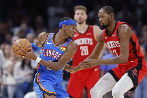 Oct 21, 2025; Oklahoma City, Oklahoma, USA; Oklahoma City Thunder guard Shai Gilgeous-Alexander (2) keeps the ball away from Houston Rockets forward Kevin Durant (7) during the second half at Paycom Center. Mandatory Credit: Alonzo Adams-Imagn Images