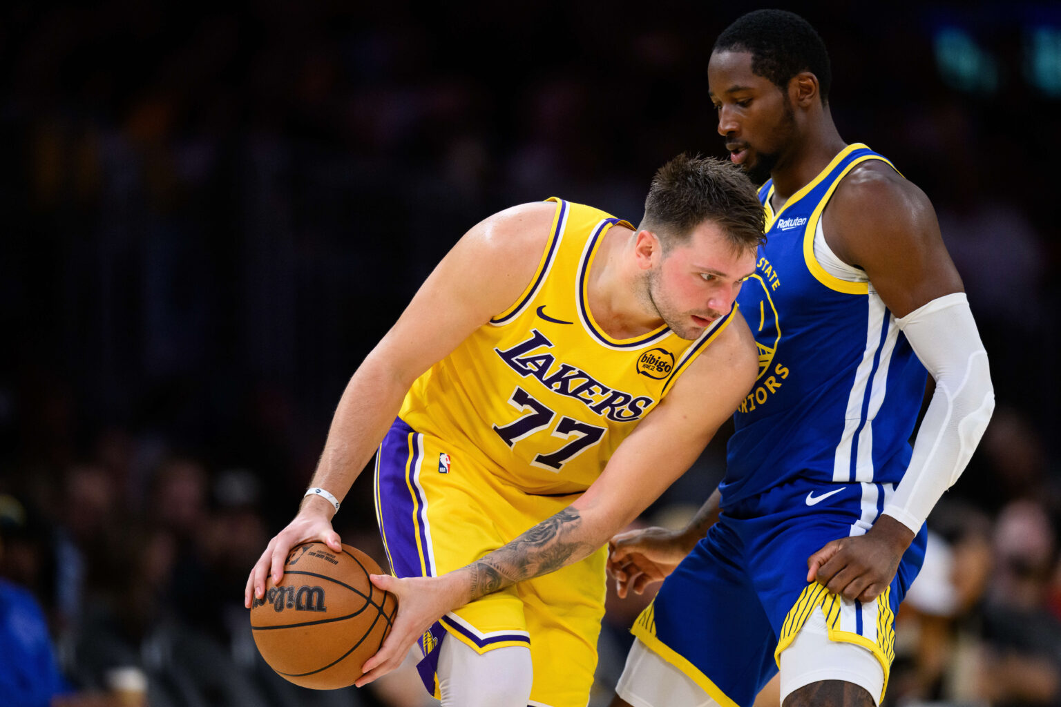 Oct 21, 2025; Los Angeles, California, USA; Los Angeles Lakers guard Luka Doncic (77) looks to drive against Golden State Warriors forward Jonathan Kuminga (1) during the second half at Crypto.com Arena. Mandatory Credit: William Liang-Imagn Images