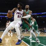 Oct 22, 2025; Boston, Massachusetts, USA;Boston Celtics forward Xavier Tillman (26) grabs hold of Philadelphia 76ers center Joel Embiid (21) during the second quarter at TD Garden. Mandatory Credit: Winslow Townson-Imagn Images