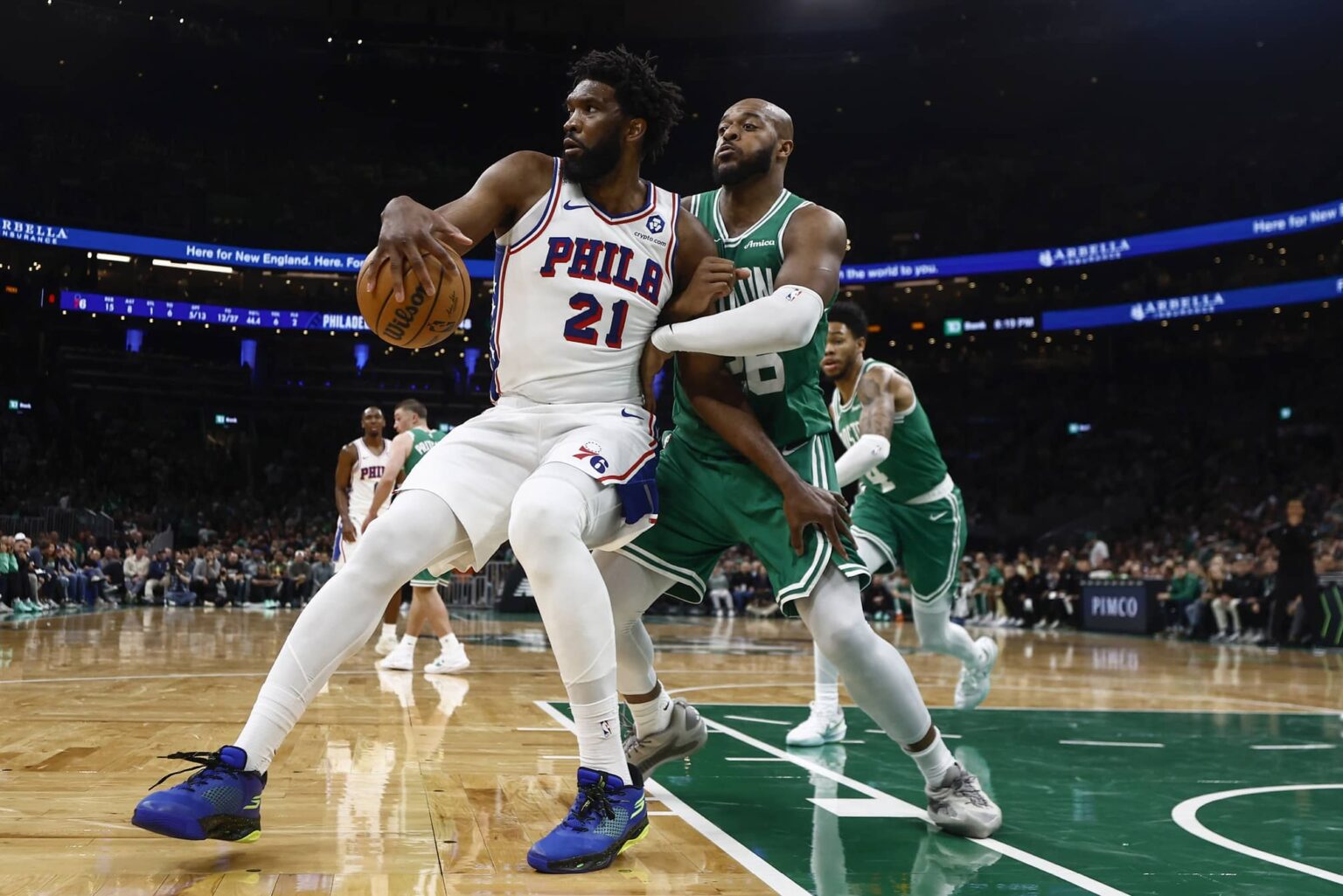 Oct 22, 2025; Boston, Massachusetts, USA;Boston Celtics forward Xavier Tillman (26) grabs hold of Philadelphia 76ers center Joel Embiid (21) during the second quarter at TD Garden. Mandatory Credit: Winslow Townson-Imagn Images