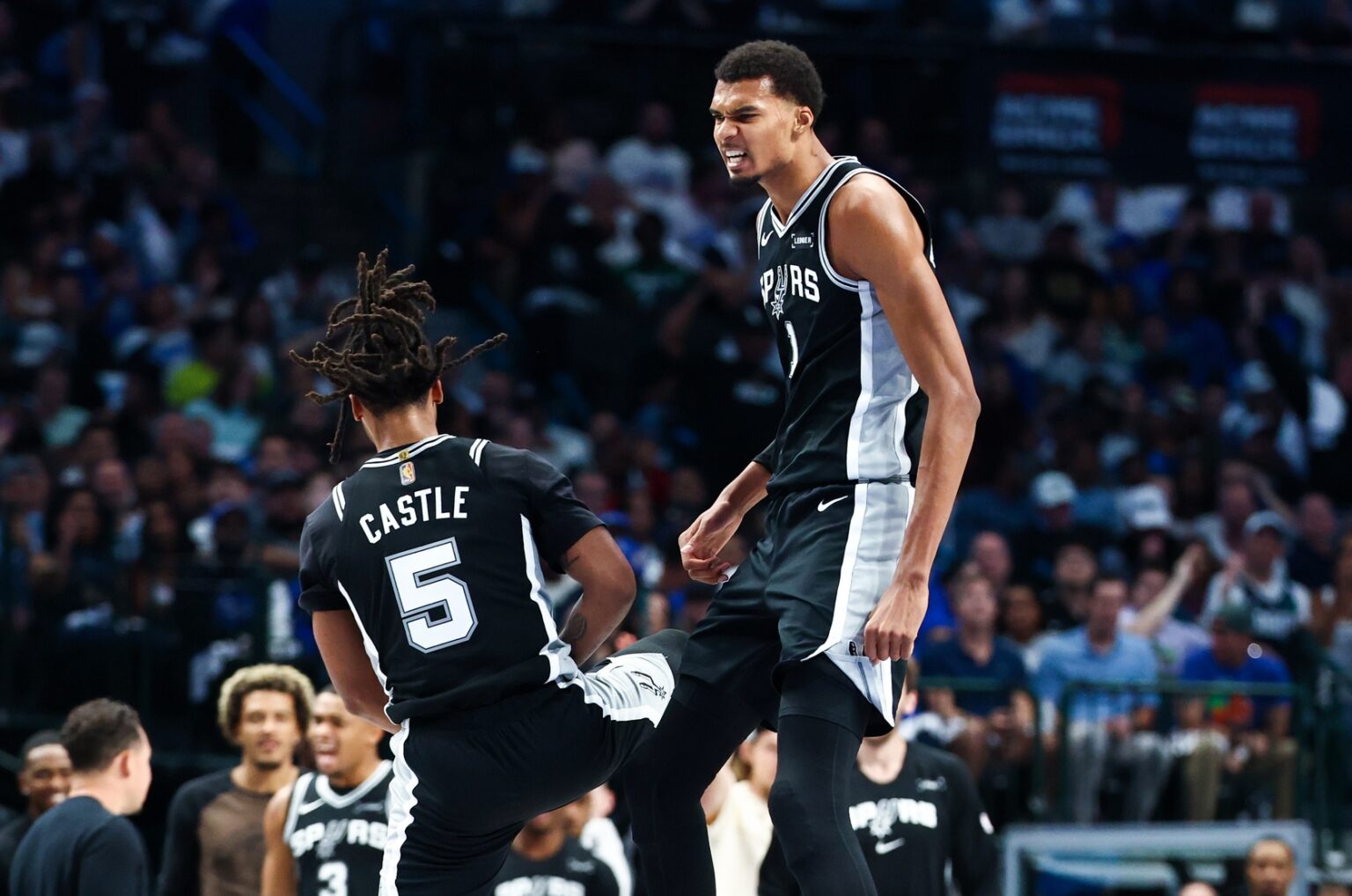 Oct 22, 2025; Dallas, Texas, USA; San Antonio Spurs forward Victor Wembanyama (1) celebrates with San Antonio Spurs guard Stephon Castle (5) during the first half against the Dallas Mavericks at American Airlines Center. Mandatory Credit: Kevin Jairaj-Imagn Images