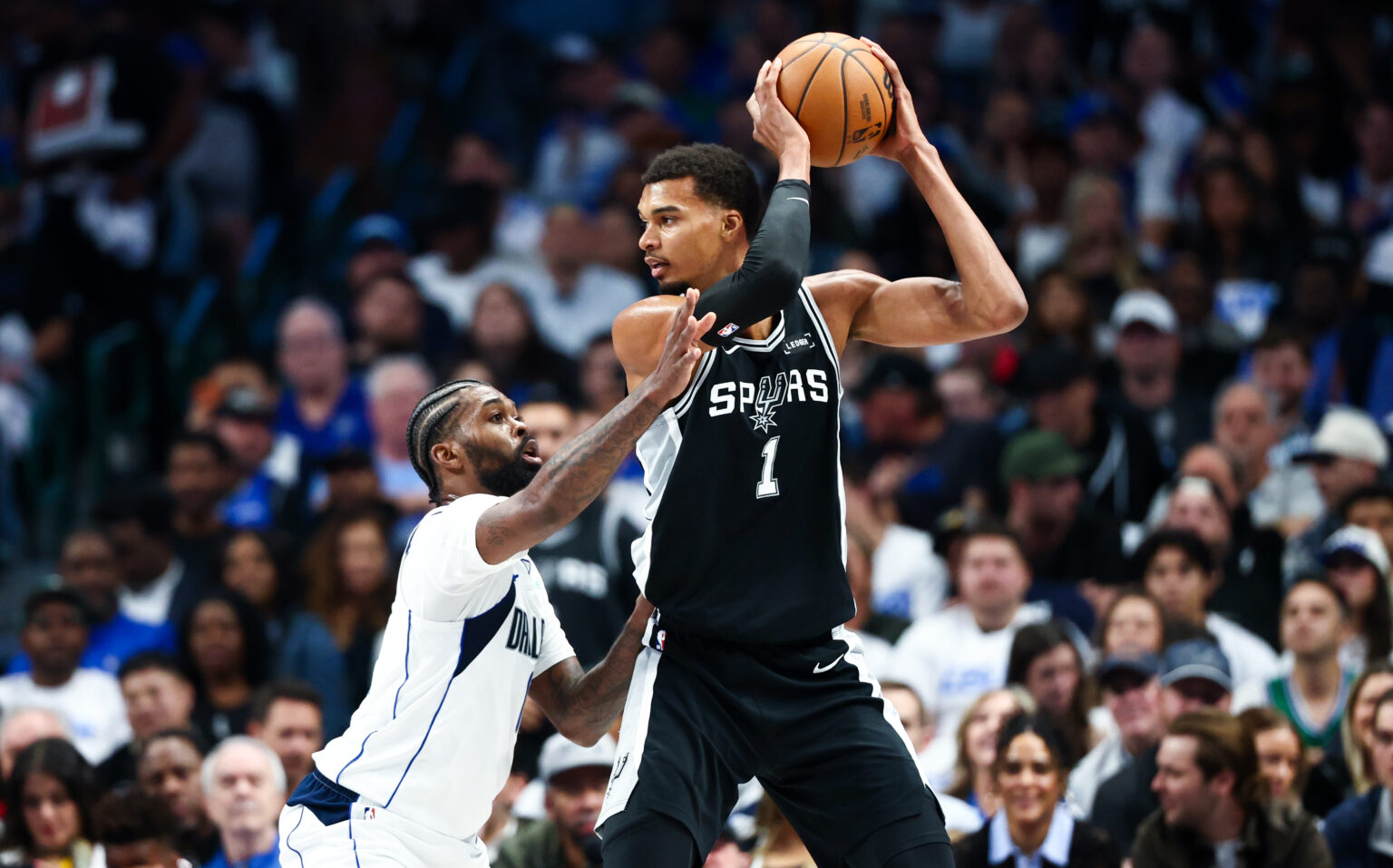 Oct 22, 2025; Dallas, Texas, USA; San Antonio Spurs forward Victor Wembanyama (1) looks to score as Dallas Mavericks forward Naji Marshall (13) defends during the first half at American Airlines Center. Mandatory Credit: Kevin Jairaj-Imagn Images