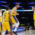 Oct 24, 2025; Los Angeles, California, USA; Los Angeles Lakers guard Luka Doncic (77) celebrates with forward Jake LaRavia (12), guard Gabe Vincent (7) and guard Austin Reaves (15) in the second half against the Minnesota Timberwolves at Crypto.com Arena. Mandatory Credit: Kirby Lee-Imagn Images