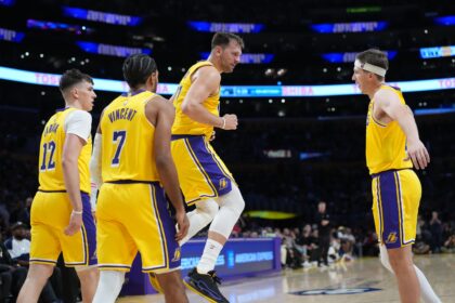 Oct 24, 2025; Los Angeles, California, USA; Los Angeles Lakers guard Luka Doncic (77) celebrates with forward Jake LaRavia (12), guard Gabe Vincent (7) and guard Austin Reaves (15) in the second half against the Minnesota Timberwolves at Crypto.com Arena. Mandatory Credit: Kirby Lee-Imagn Images