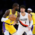 Oct 27, 2025; Los Angeles, California, USA; Los Angeles Lakers center Deandre Ayton (5) looks to pass the ball while under pressure from Portland Trail Blazers forward Deni Avdija (8) during the first half at Crypto.com Arena. Mandatory Credit: William Liang-Imagn Images