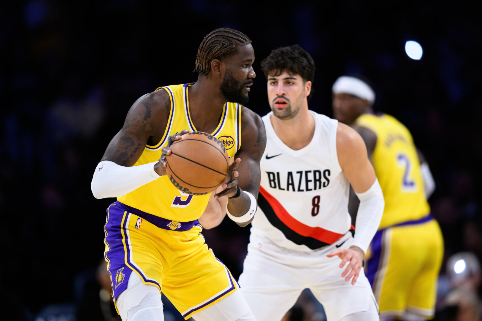 Oct 27, 2025; Los Angeles, California, USA; Los Angeles Lakers center Deandre Ayton (5) looks to pass the ball while under pressure from Portland Trail Blazers forward Deni Avdija (8) during the first half at Crypto.com Arena. Mandatory Credit: William Liang-Imagn Images