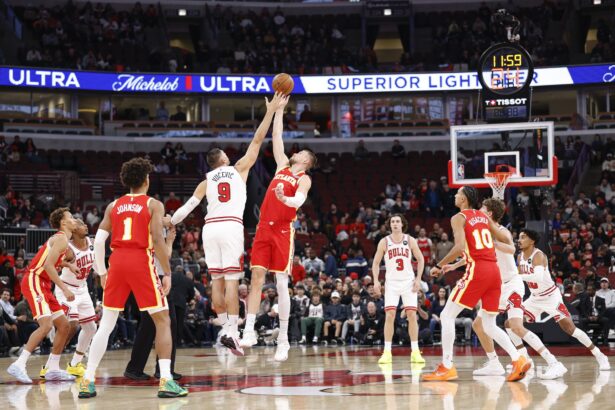 Oct 27, 2025; Chicago, Illinois, USA; Chicago Bulls center Nikola Vucevic (9) battles for the ball with Atlanta Hawks center Kristaps Porzingis (8) at the tip-off of an NBA game at United Center. Mandatory Credit: Kamil Krzaczynski-Imagn Images