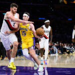 Oct 27, 2025; Los Angeles, California, USA; Los Angeles Lakers guard Austin Reaves (15) drives the ball under pressure from Portland Trail Blazers center Donovan Clingan (23) during the second half at Crypto.com Arena. Mandatory Credit: William Liang-Imagn Images