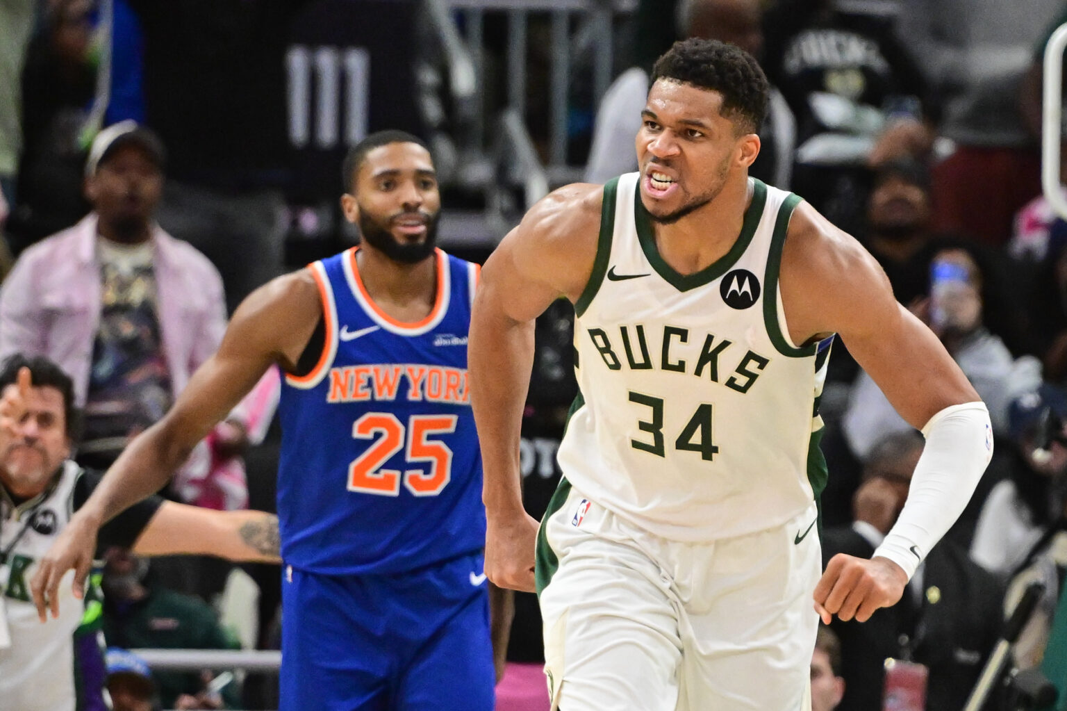 Oct 28, 2025; Milwaukee, Wisconsin, USA; Milwaukee Bucks forward Giannis Antetokounmpo (34) reacts after scoring a basket in the 3rd quarter as New York Knicks guard Mikal Bridges (25) looks on at Fiserv Forum. Mandatory Credit: Benny Sieu-Imagn Images