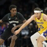 Oct 29, 2025; Minneapolis, Minnesota, USA; Los Angeles Lakers guard Austin Reaves (15) dribbles the ball as Minnesota Timberwolves forward Jaden McDaniels (3) plays defense in the first half at Target Center. Mandatory Credit: Jesse Johnson-Imagn Images