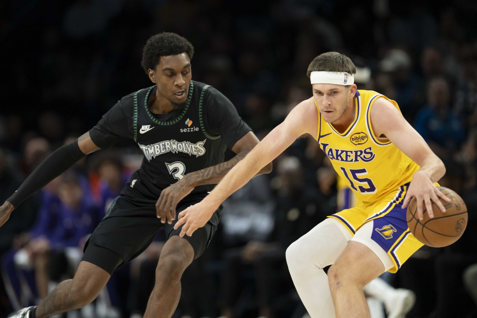 Oct 29, 2025; Minneapolis, Minnesota, USA; Los Angeles Lakers guard Austin Reaves (15) dribbles the ball as Minnesota Timberwolves forward Jaden McDaniels (3) plays defense in the first half at Target Center. Mandatory Credit: Jesse Johnson-Imagn Images