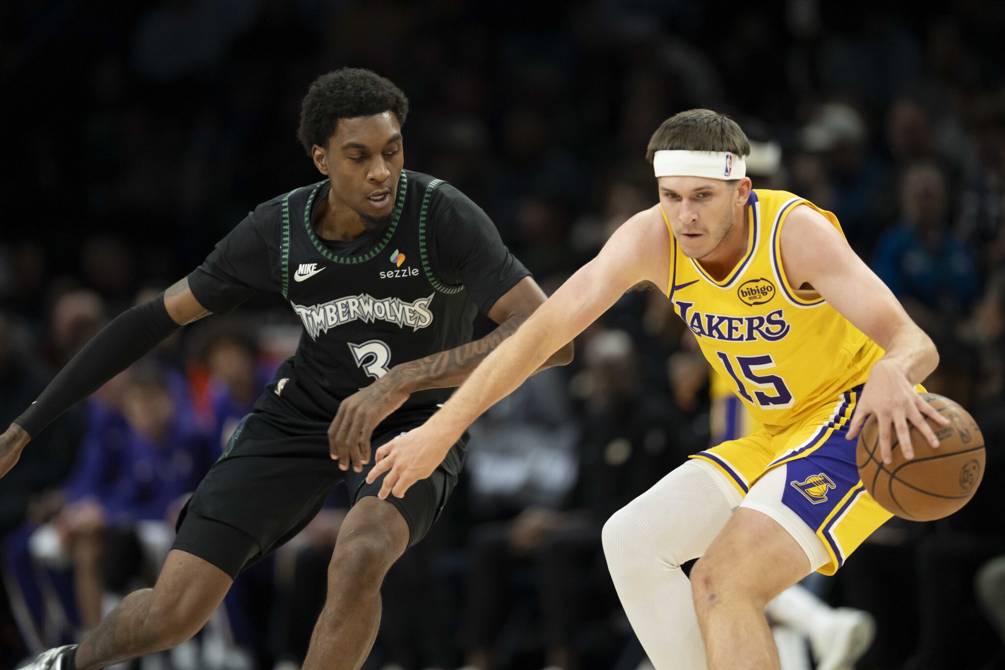Oct 29, 2025; Minneapolis, Minnesota, USA; Los Angeles Lakers guard Austin Reaves (15) dribbles the ball as Minnesota Timberwolves forward Jaden McDaniels (3) plays defense in the first half at Target Center. Mandatory Credit: Jesse Johnson-Imagn Images