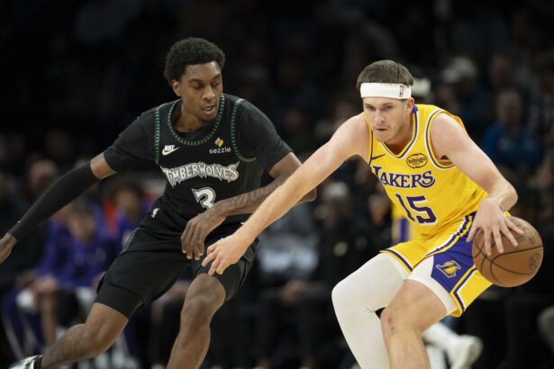 Oct 29, 2025; Minneapolis, Minnesota, USA; Los Angeles Lakers guard Austin Reaves (15) dribbles the ball as Minnesota Timberwolves forward Jaden McDaniels (3) plays defense in the first half at Target Center. Mandatory Credit: Jesse Johnson-Imagn Images