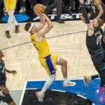 Oct 29, 2025; Minneapolis, Minnesota, USA; Los Angeles Lakers guard Austin Reaves (15) shoots a game winning shot over Minnesota Timberwolves guard Donte DiVincenzo (0) in the second half at Target Center. Mandatory Credit: Jesse Johnson-Imagn Images