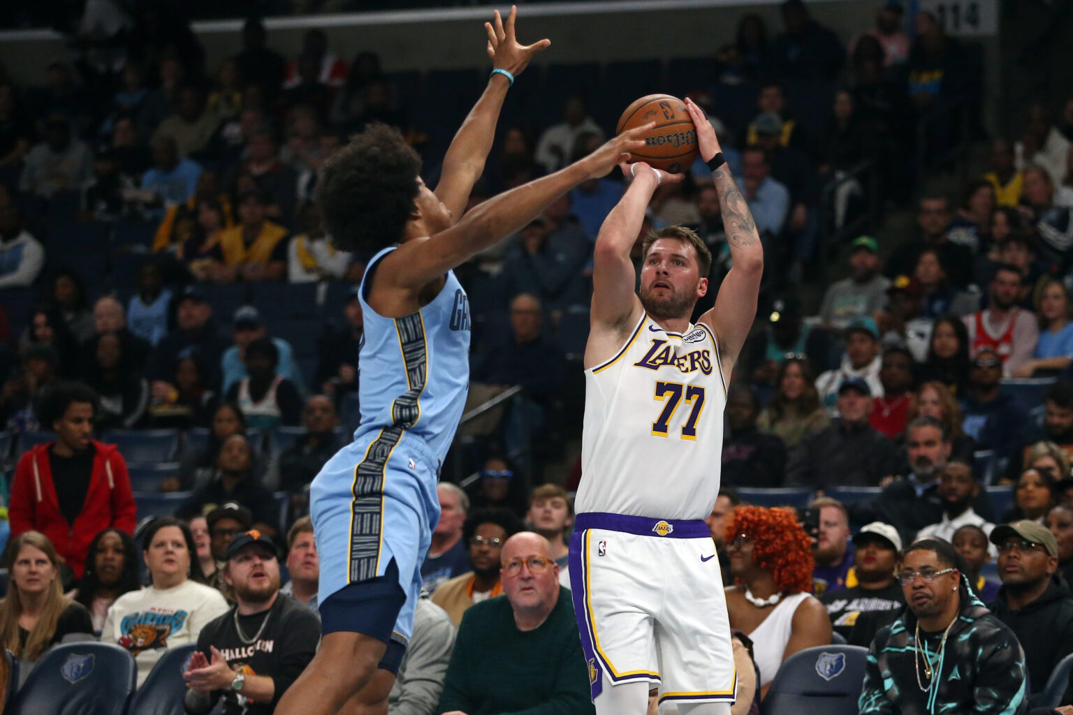 Oct 31, 2025; Memphis, Tennessee, USA; Los Angeles Lakers guard Luka Doncic (77) shoots for three as Memphis Grizzlies forward Jaylen Wells (0) defends during the first quarter at FedExForum. Mandatory Credit: Petre Thomas-Imagn Images
