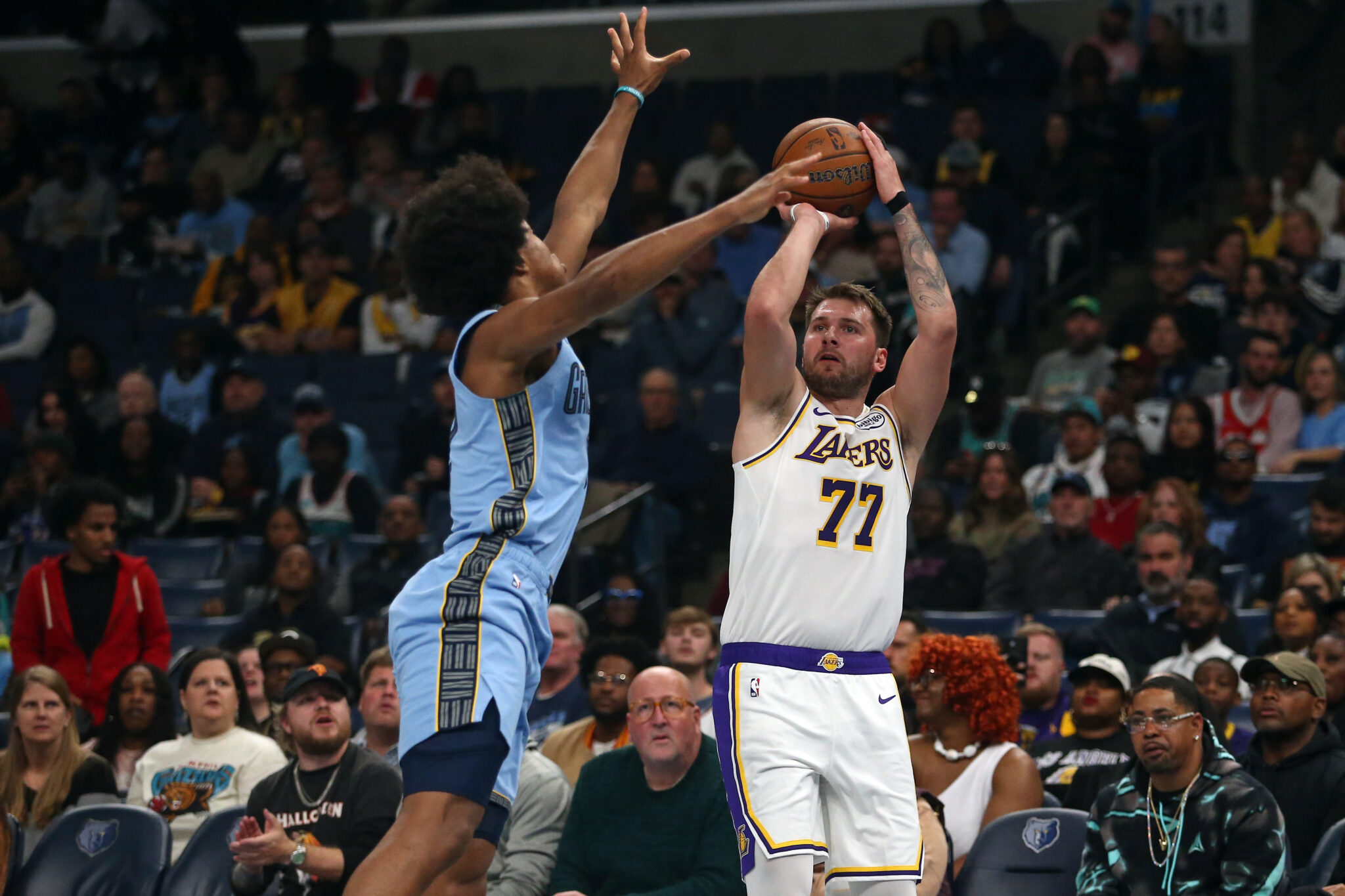 Oct 31, 2025; Memphis, Tennessee, USA; Los Angeles Lakers guard Luka Doncic (77) shoots for three as Memphis Grizzlies forward Jaylen Wells (0) defends during the first quarter at FedExForum. Mandatory Credit: Petre Thomas-Imagn Images