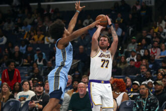 Oct 31, 2025; Memphis, Tennessee, USA; Los Angeles Lakers guard Luka Doncic (77) shoots for three as Memphis Grizzlies forward Jaylen Wells (0) defends during the first quarter at FedExForum. Mandatory Credit: Petre Thomas-Imagn Images