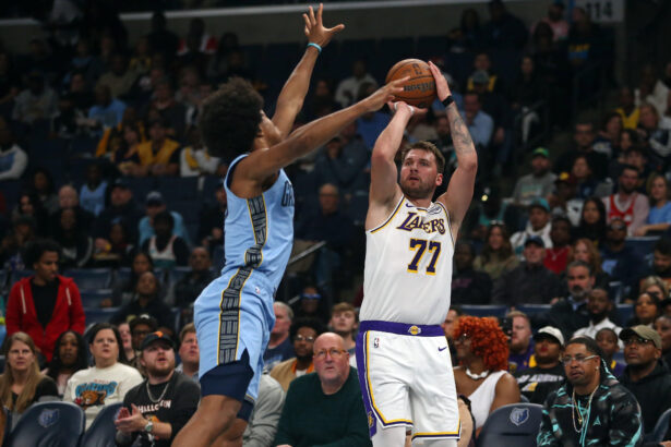 Oct 31, 2025; Memphis, Tennessee, USA; Los Angeles Lakers guard Luka Doncic (77) shoots for three as Memphis Grizzlies forward Jaylen Wells (0) defends during the first quarter at FedExForum. Mandatory Credit: Petre Thomas-Imagn Images