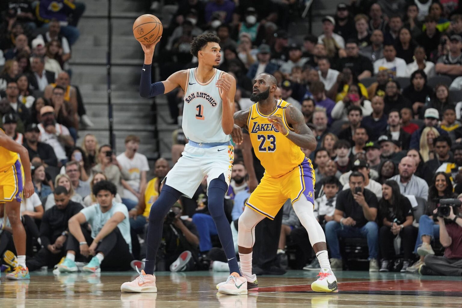 San Antonio Spurs center Victor Wembanyama (1) handles the ball in front of Los Angeles Lakers forward LeBron James (23) in the second half at Frost Bank Center.