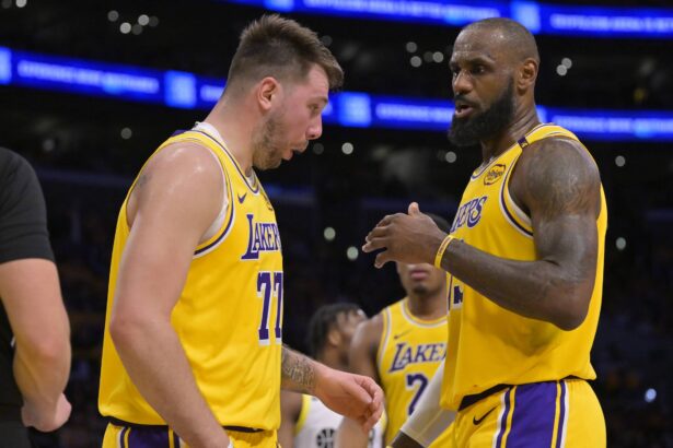 Los Angeles, California, USA; Los Angeles Lakers forward LeBron James (23) checks on guard Luka Doncic (77) after he was hit in the face against the Utah Jazz at Crypto.com Arena. Mandatory Credit: Jayne Kamin-Oncea-Imagn Images