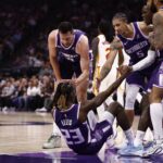 Nov 12, 2025; Sacramento, California, USA; Sacramento Kings teammates help up guard Keon Ellis (23) after drawing an offensive foul against the Atlanta Hawks during the first quarter at Golden 1 Center. Mandatory Credit: Kelley L Cox-Imagn Images
