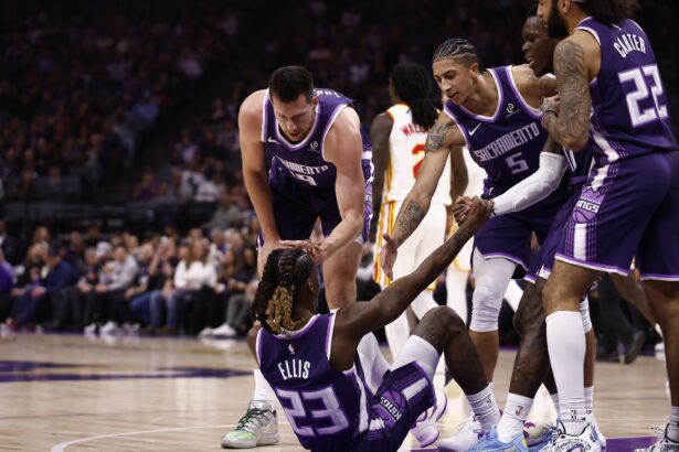 Nov 12, 2025; Sacramento, California, USA; Sacramento Kings teammates help up guard Keon Ellis (23) after drawing an offensive foul against the Atlanta Hawks during the first quarter at Golden 1 Center. Mandatory Credit: Kelley L Cox-Imagn Images