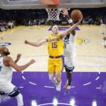 Oct 24, 2025; Los Angeles, California, USA; Los Angeles Lakers guard Austin Reaves (15) shoots the ball against Minnesota Timberwolves center Rudy Gobert (27) and center Naz Reid (11) in the first half at Crypto.com Arena. Mandatory Credit: Kirby Lee-Imagn Images