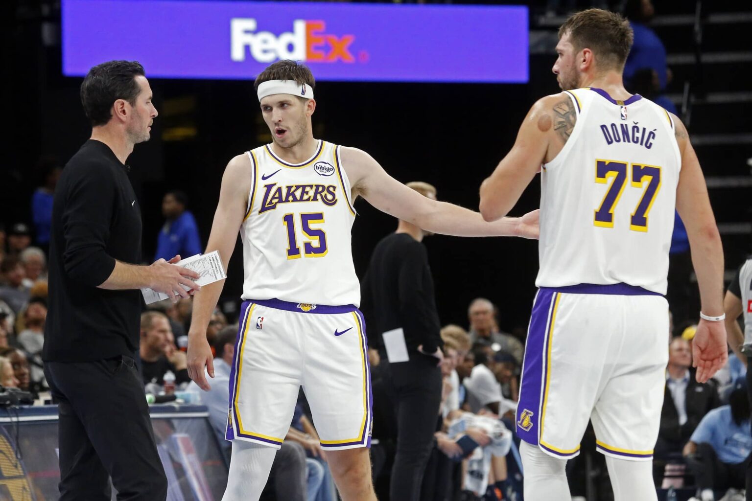 Los Angeles Lakers head coach JJ Redick talks with guard Austin Reaves (15) and guard Luka Doncic (77) during the fourth quarter against the Memphis Grizzlies at FedExForum.