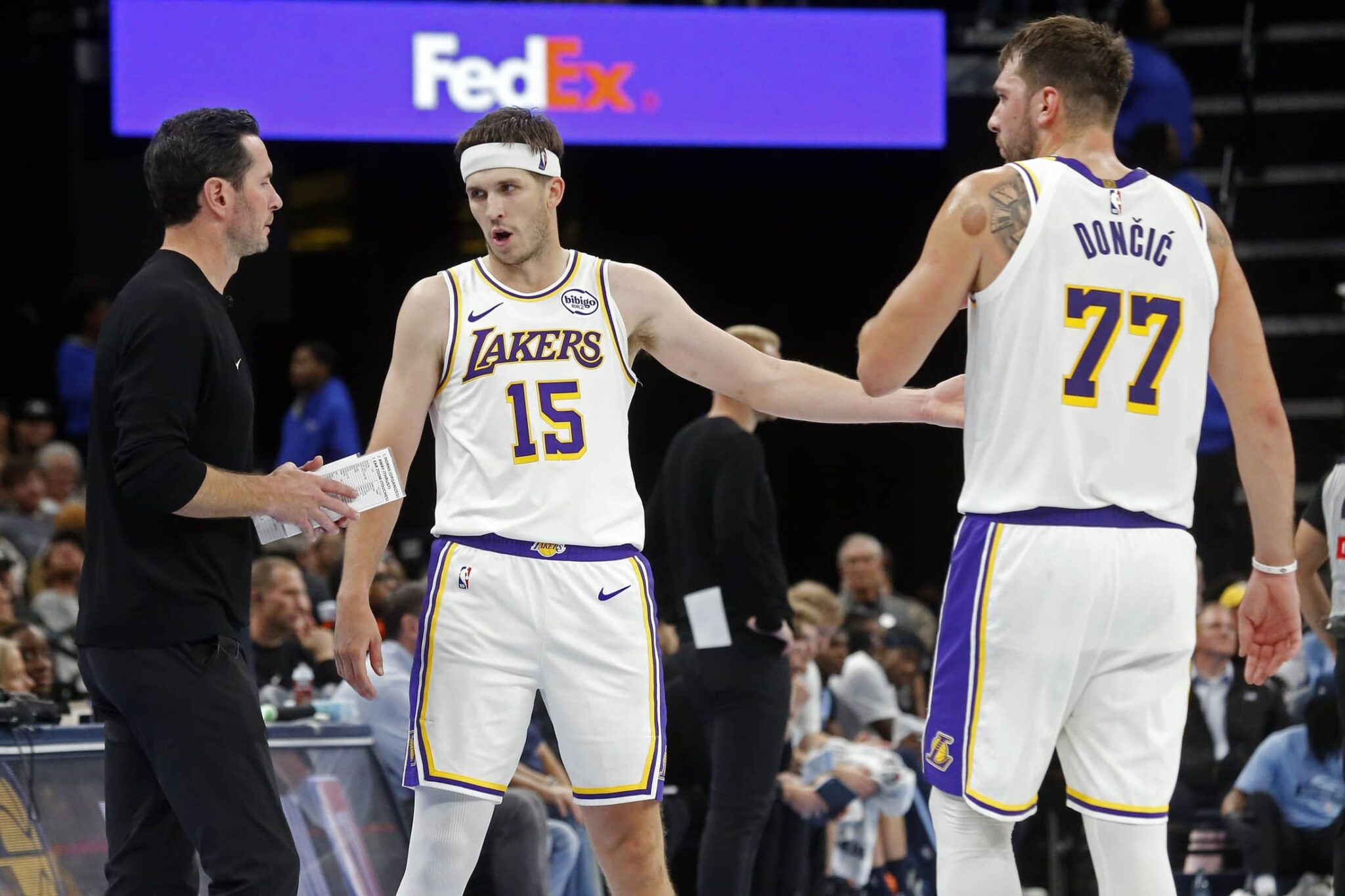 Los Angeles Lakers head coach JJ Redick talks with guard Austin Reaves (15) and guard Luka Doncic (77) during the fourth quarter against the Memphis Grizzlies at FedExForum.