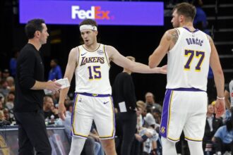 Los Angeles Lakers head coach JJ Redick talks with guard Austin Reaves (15) and guard Luka Doncic (77) during the fourth quarter against the Memphis Grizzlies at FedExForum.