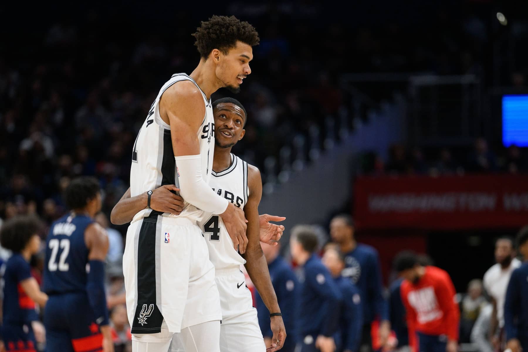 San Antonio Spurs center Victor Wembanyama (1) and guard De'Aaron Fox (4) react during the second quarter against the Washington Wizards at Capital One Arena.