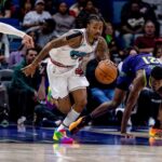 Mar 9, 2025; New Orleans, Louisiana, USA; Memphis Grizzlies guard Ja Morant (12) brings the ball up court against New Orleans Pelicans center Yves Missi (21) during the second half at Smoothie King Center. Mandatory Credit: Stephen Lew-Imagn Images