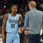 Nov 7, 2025; Memphis, Tennessee, USA; Memphis Grizzlies guard Ja Morant (12) shakes hands with head coach Tuomas Iisalo (obscured) during a substitution in the first quarter against the Dallas Mavericks at FedExForum. Mandatory Credit: Petre Thomas-Imagn Images
