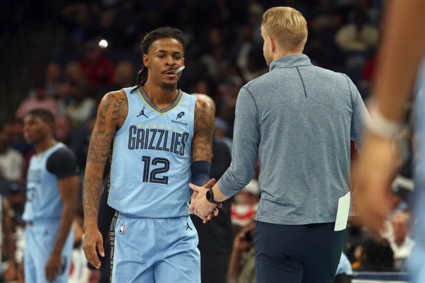 Nov 7, 2025; Memphis, Tennessee, USA; Memphis Grizzlies guard Ja Morant (12) shakes hands with head coach Tuomas Iisalo (obscured) during a substitution in the first quarter against the Dallas Mavericks at FedExForum. Mandatory Credit: Petre Thomas-Imagn Images