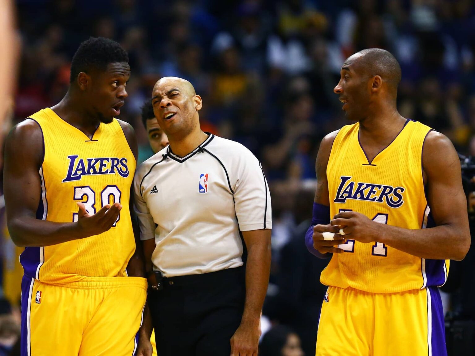 NBA referee Karl Lane talks with Los Angeles Lakers forward Julius Randle (30) and guard Kobe Bryant against the Phoenix Suns at Talking Stick Resort Arena. The Suns defeated the Lakers 119-107.