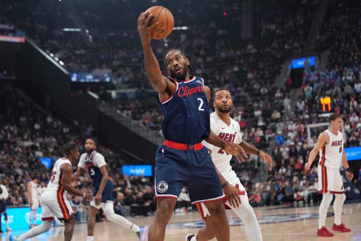 Nov 3, 2025; Inglewood, California, USA; LA Clippers forward Kawhi Leonard (2) reaches for the ball against Miami Heat guard Norman Powell (24) in the first half at Intuit Dome. Mandatory Credit: Kirby Lee-Imagn Images