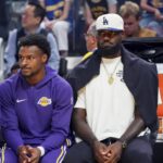 Los Angeles Lakers guard Bronny James (9) and forward LeBron James (23), wearing a Los Angeles Dodgers cap, watch the action against the Golden State Warriors in the first quarter at Chase Center.