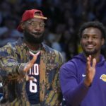 Los Angeles Lakers forward LeBron James (left) and son Bronny James watch from the bench in the second half against the Minnesota Timberwolves at Crypto.com Arena.