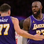 Los Angeles Lakers guard Luka Doncic (77) and forward LeBron James (23) react after a foul during the first half against the Los Angeles Clippers at Crypto.com Arena.