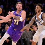 Los Angeles Lakers guard Luka Doncic (77) is defended by Dallas Mavericks forward P.J. Washington (25) as he drives to the basket in the first half at Crypto.com Arena.